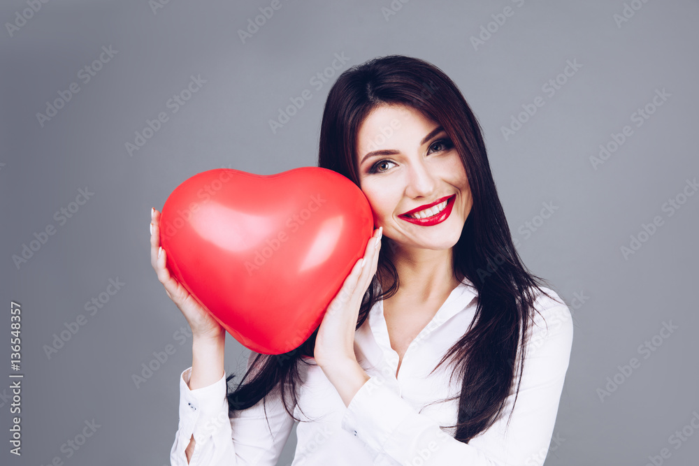 Beautiful girl holding a heart shape symbol in hands. Beautiful girl holding a heart shape symbol in hands.