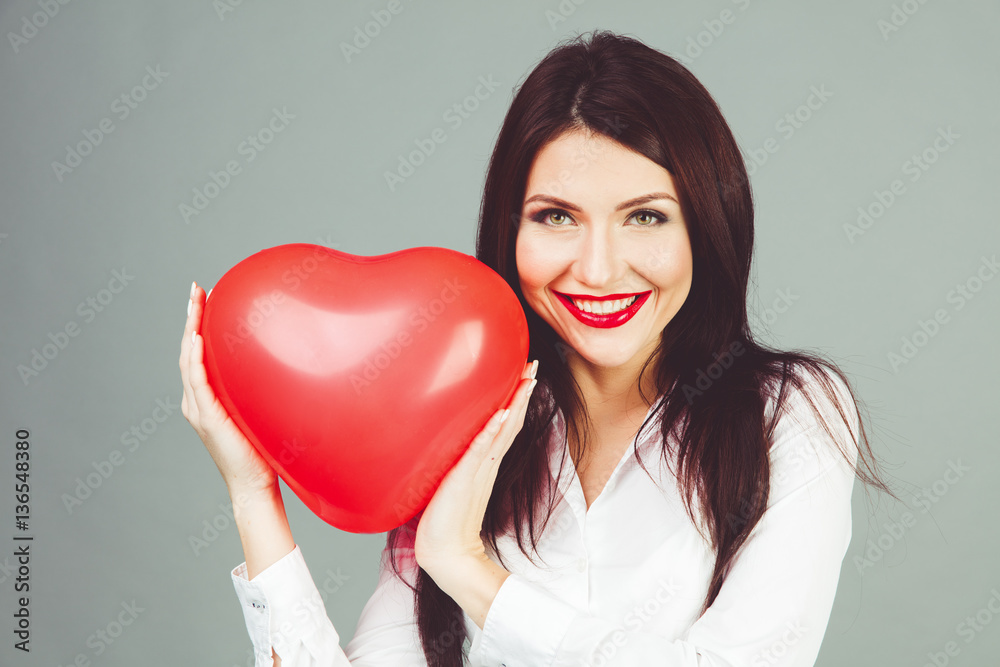 Beautiful girl holding a heart shape symbol in hands. Beautiful girl holding a heart shape symbol in hands.