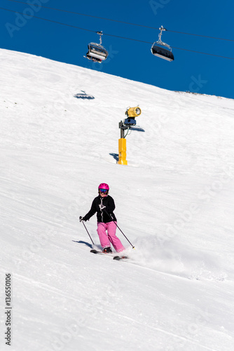 Female skier in fresh powder snow and blue sky