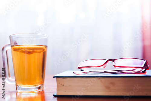 a pile of books, glasses and coffee cup photo