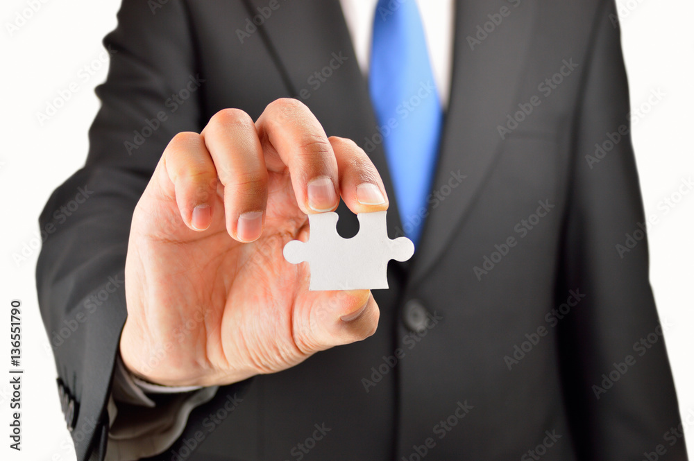 Fototapeta premium Business man showing jigsaw puzzle