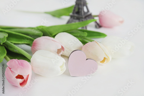 spring and holiday card eiffel tower and pink and white tulips on white background with selective focus