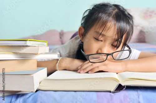 asian child sleeping while reading in the bed, selective focus