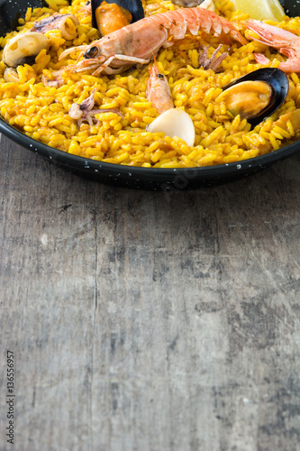 Traditional spanish seafood paella on wooden background 