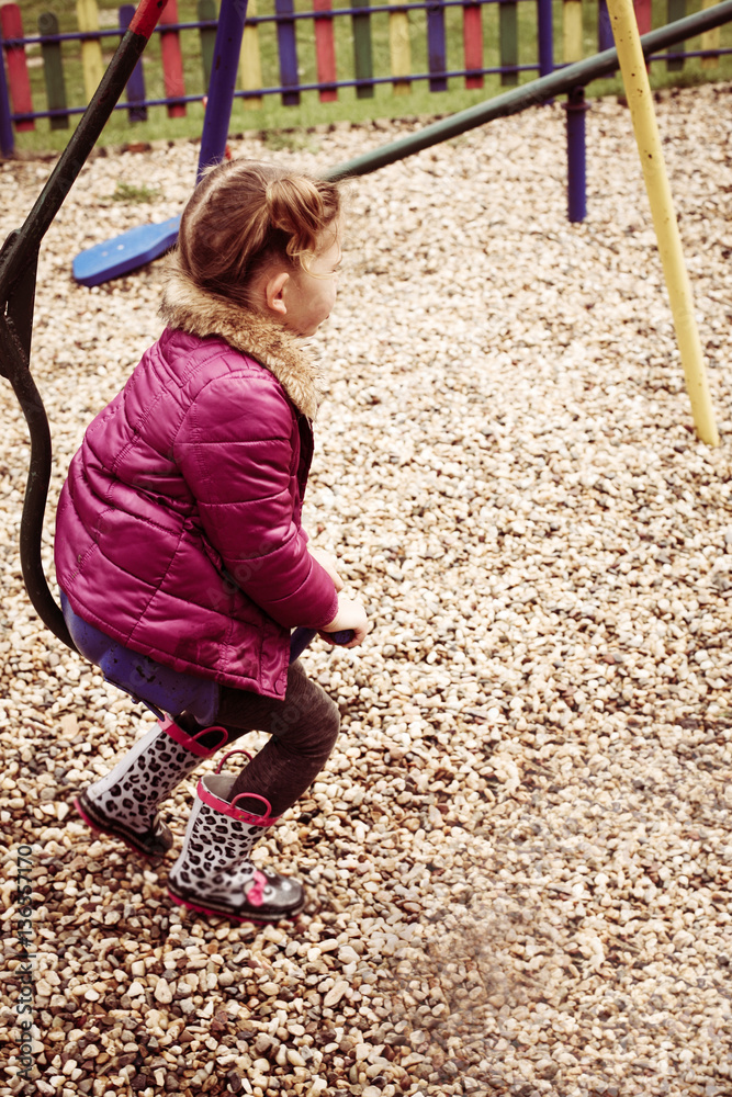 Little girl on the swing in the park. Little girl on the swing in the park.