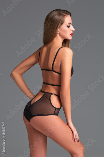 A studio shot of a beautiful and sexy girl with long hair wearing black lingerie