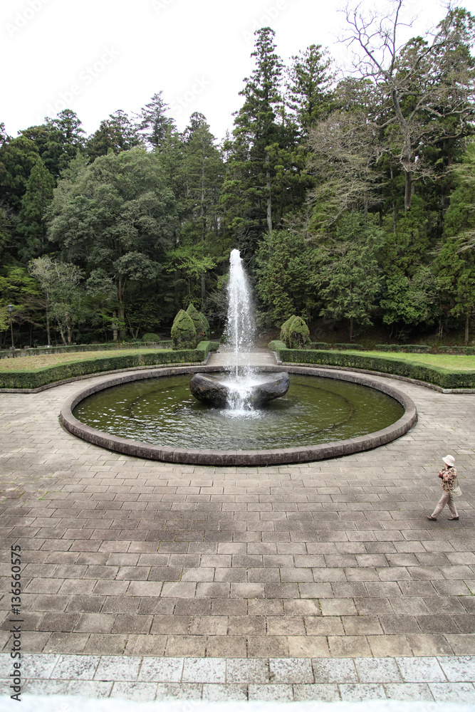 Female tourist walking around a fountain in Naritasan Temple, Na