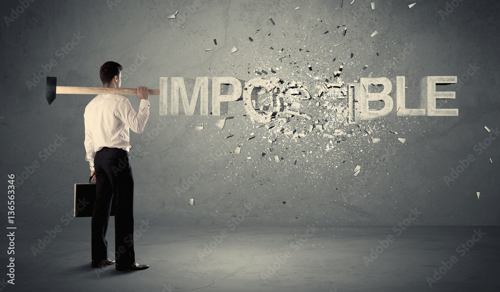 Fototapeta premium Business man hitting impossible sign with hammer