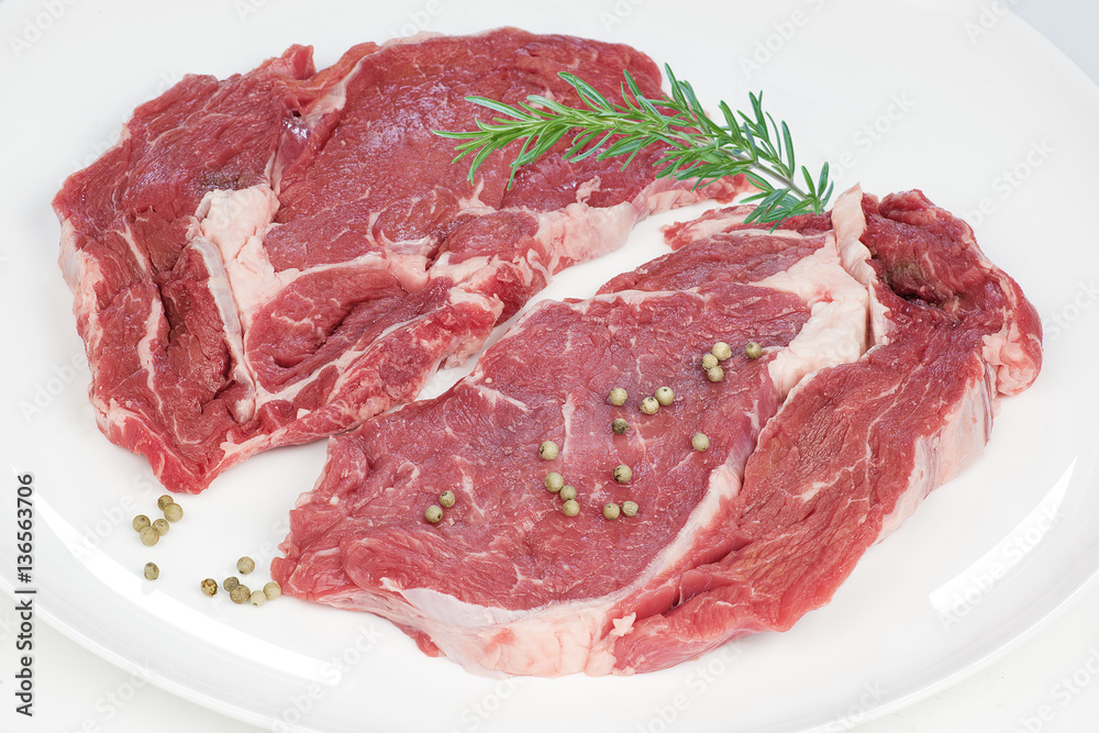 deux entrecôtes de boeuf crues sur fond blanc deux entrecôtes de boeuf crues sur fond blanc