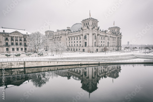 Reichstag building (Bundestag) and with reflection in river Spree in Winter, Berlin government district, Germany, Europe, bright retro style