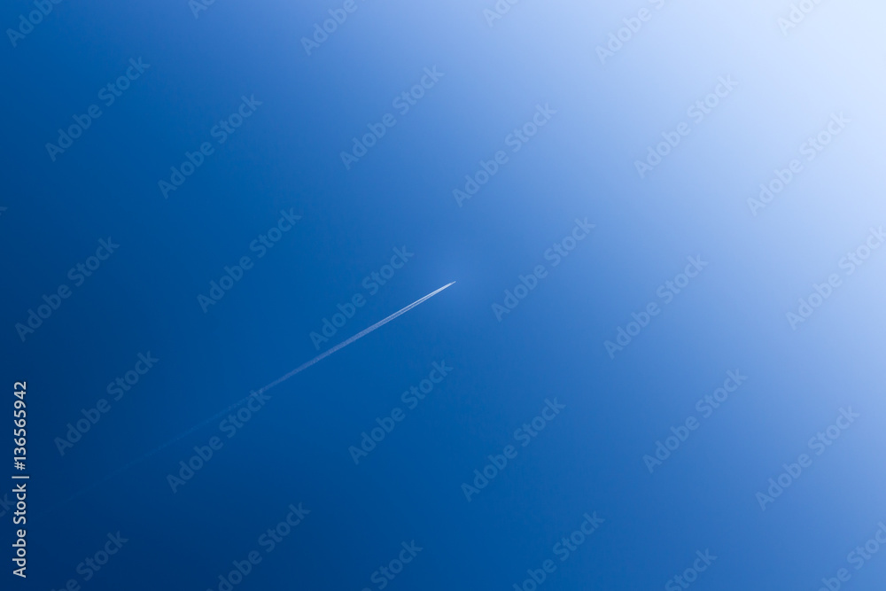 Fototapeta premium Airplane soars into the blue sky