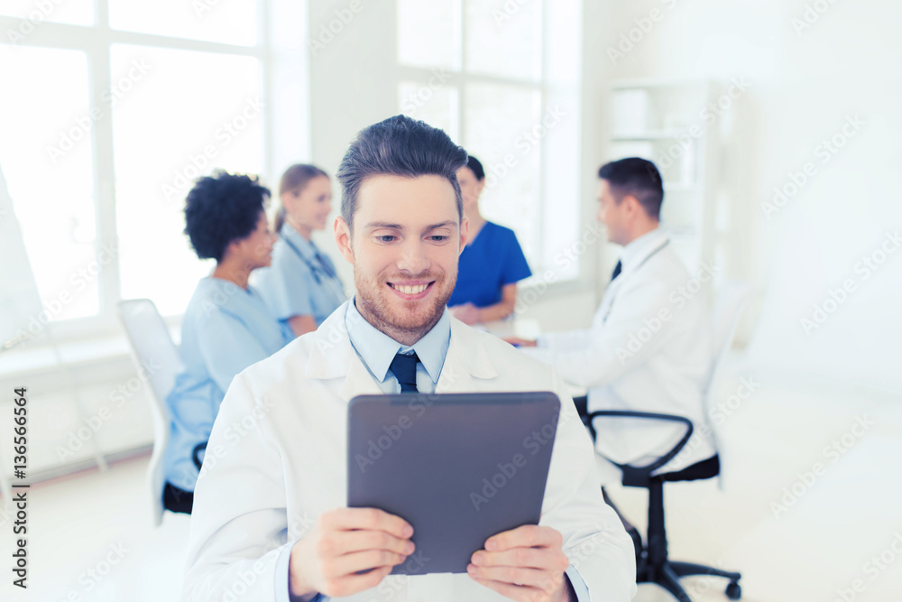 happy doctor with tablet pc over team at clinic happy doctor with tablet pc over team at clinic