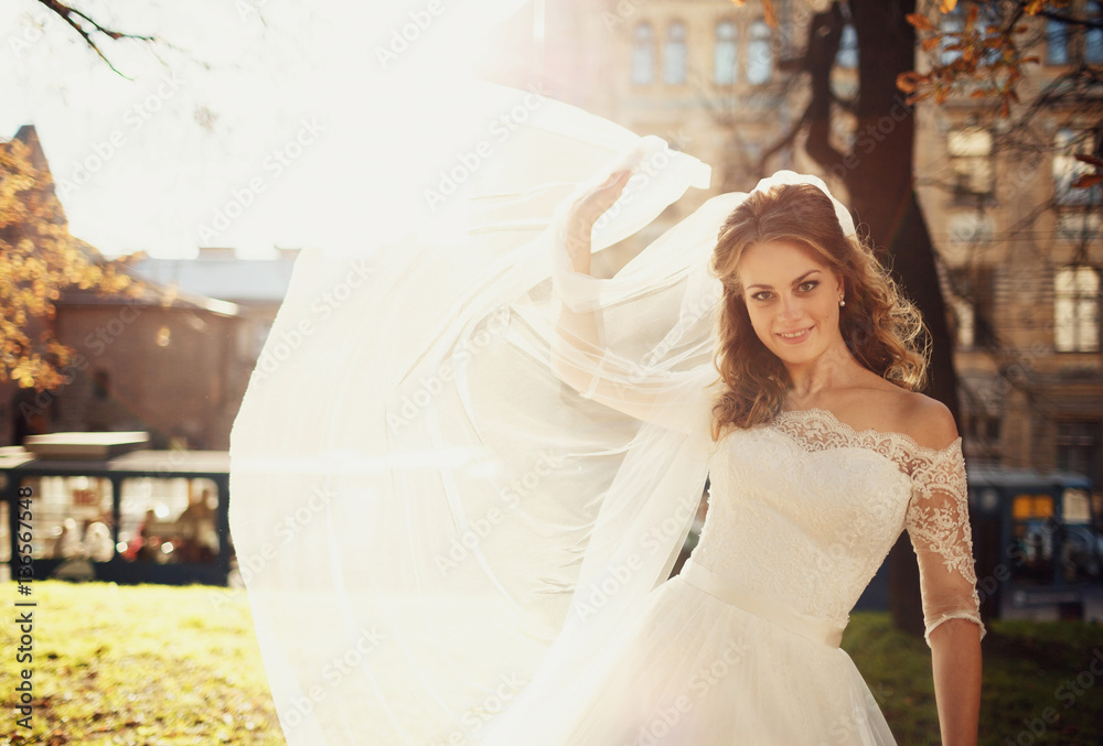 Fototapeta premium Happy beautiful bride posing in the old city