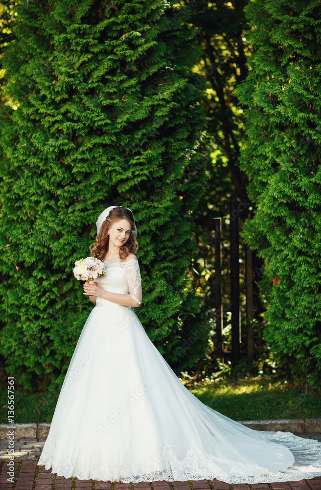 Portrait of beautiful happy bride in luxury weding gown