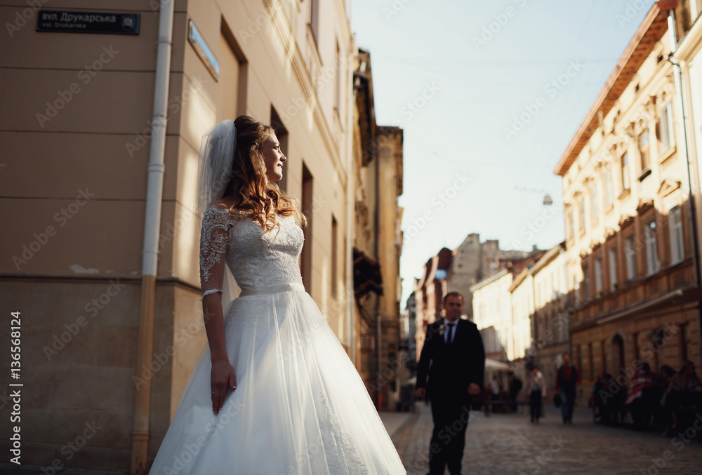 Obraz premium Happy beautiful newlyweds posing in the old city