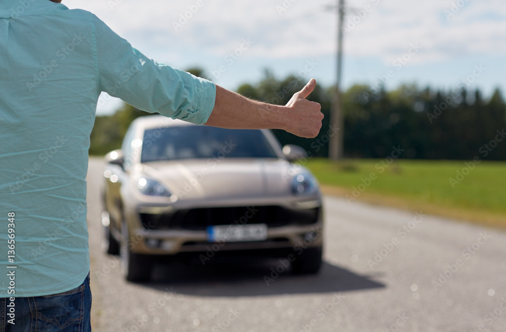 man hitchhiking and stopping car with thumbs up