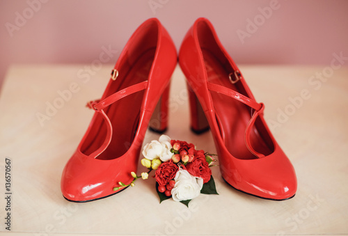 Bridal shoes and boutonniere with the red flowers