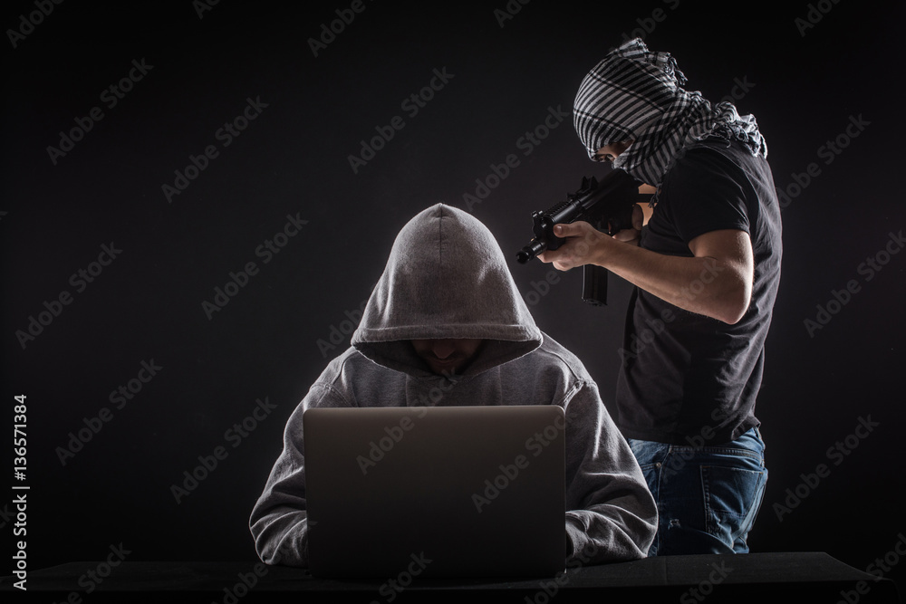 Terrorist attack hacker with gun work at laptop. Terrorist attack hacker with gun work at laptop.