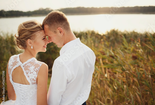 Beautiful bride next to her groom on the sunset