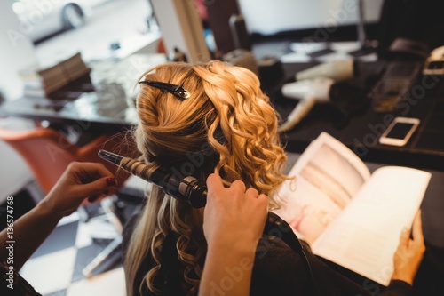 Female hairdresser styling clients hair