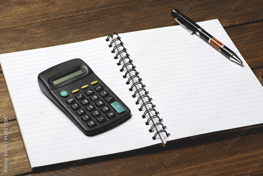 Office supplies with pen and calculator on brown wooden table. Office supplies with pen and calculator on brown wooden table.