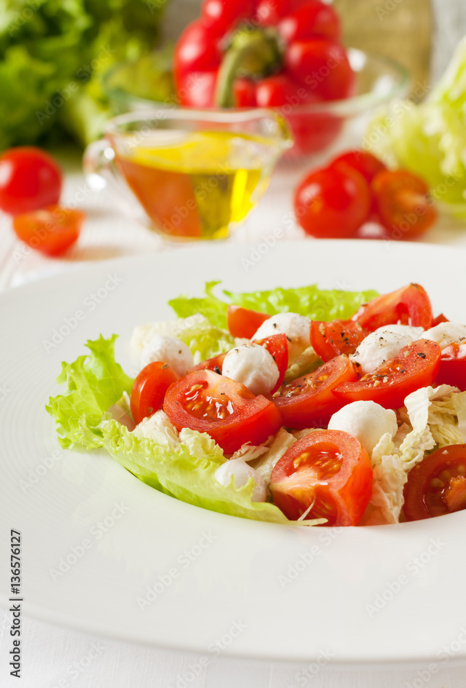 Salad with cherry tomatoes mozzarella, greens. Close-up.
