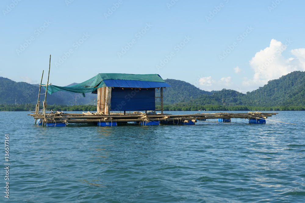 Fototapeta premium Bamboo raft floating on water with mountain background