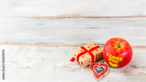 Message I love you written on a red apple. Valentine's day table place setting. Wedding background.