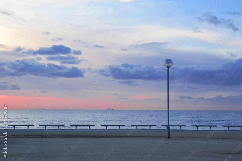 Promenade in Barcelona at sunrise. Some benches and a street light. Empty copy space for Editor's text.