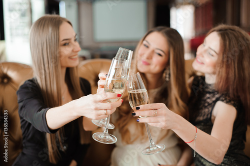Cheerful girls clinking glasses of champagne at the party