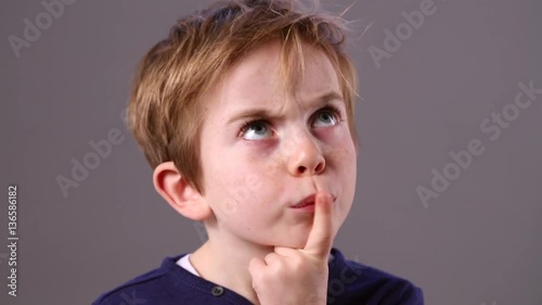 smart little child with a finger on his mouth to imagine