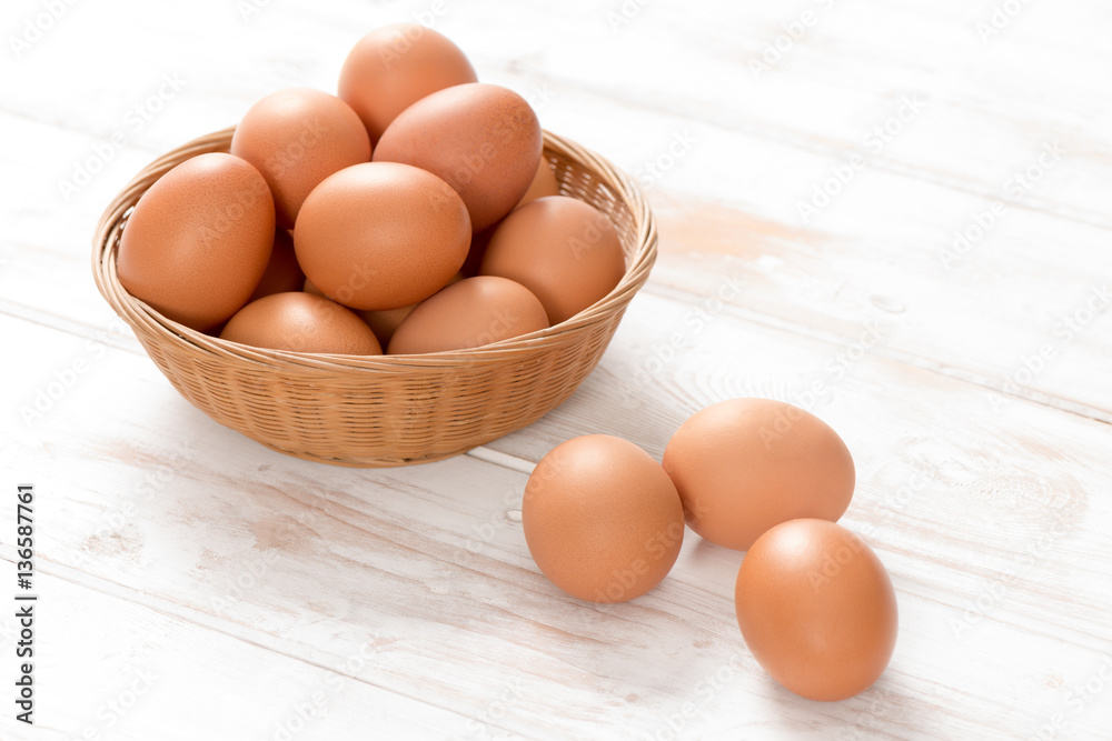 Brown Chicken Eggs in Basket and on Wooden Surface Brown Chicken Eggs in Basket and on Wooden Surface