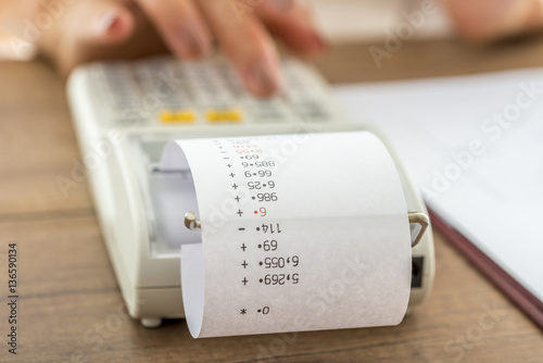 Woman using a manual adding machine