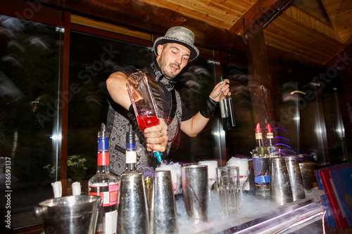 Canvas Print Bartender with bottles with alcoholic drinks on cocktail party