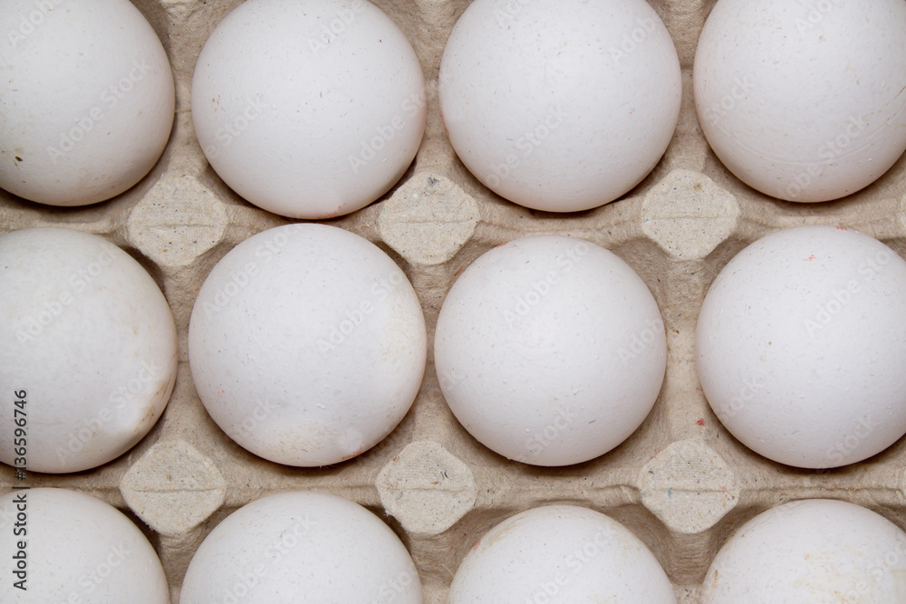 Eggs in paper tray on white background