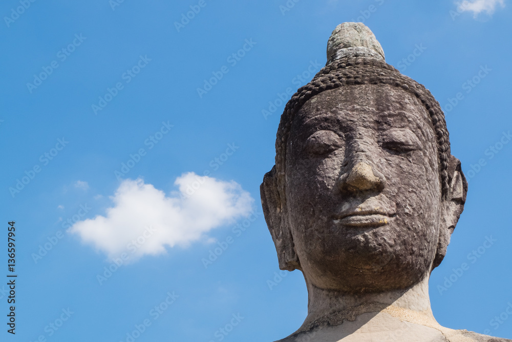 Close up of Buddha head with blue sky in Wat Mahathat, the historical Park of Ayutthaya,