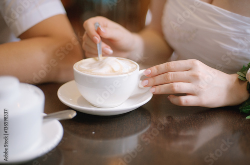 girl's hands with a cup of coffee and spoon