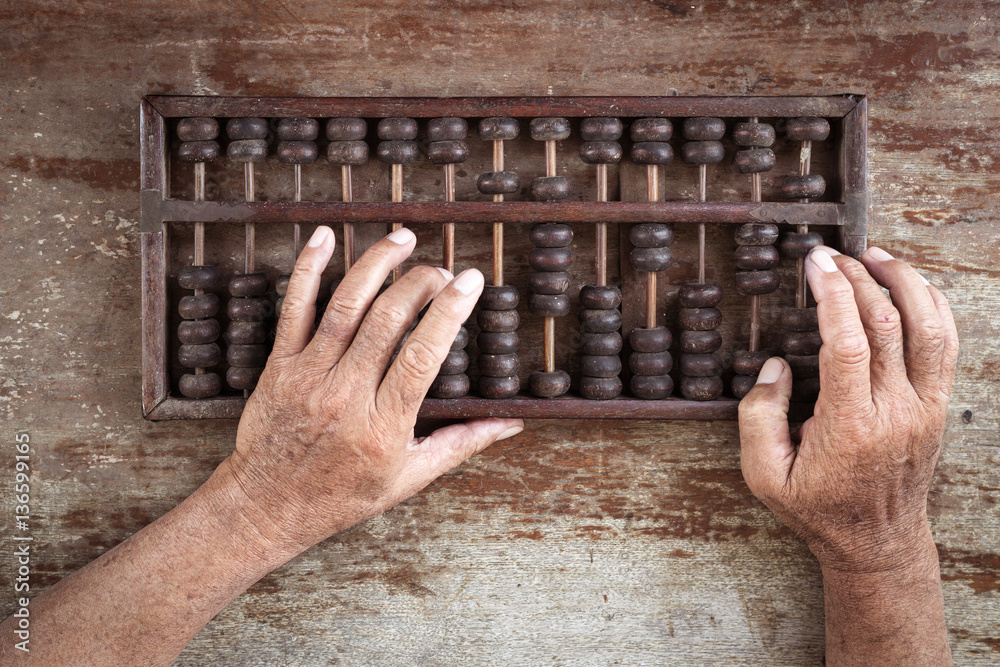 Obraz premium old abacus and hand on wooden background