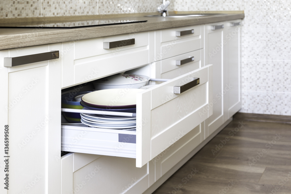 Opened kitchen drawer with plates inside, a smart solution for kitchen storage and organizing. Opened kitchen drawer with plates inside, a smart solution for kitchen storage and organizing.