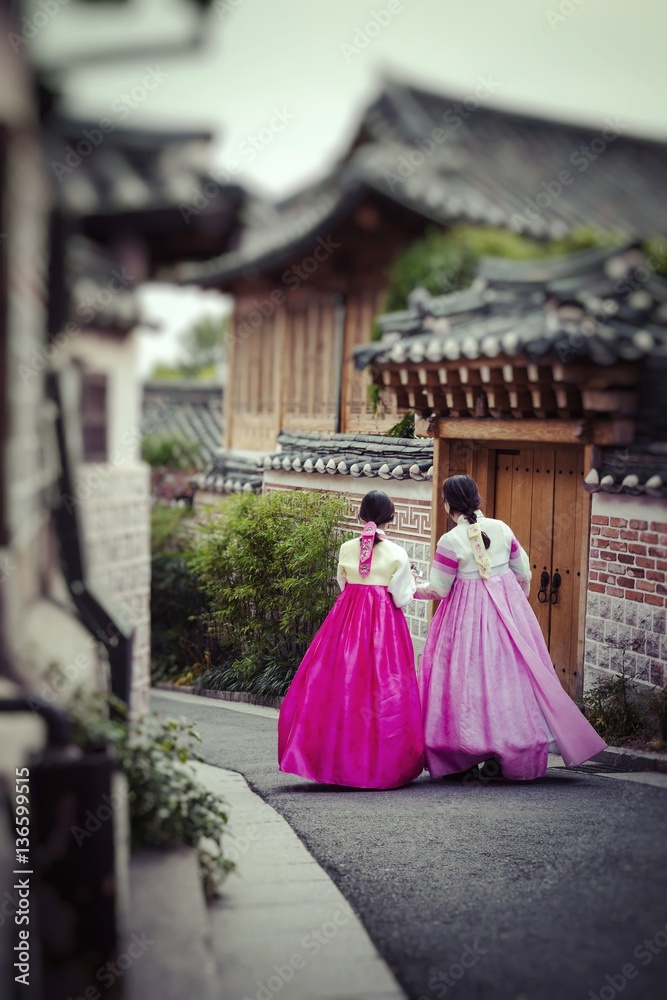 Fototapeta premium Kilka kobiet spaceruje po tradycyjnych domach w wiosce Bukchon Hanok w Seulu w Korei Południowej.