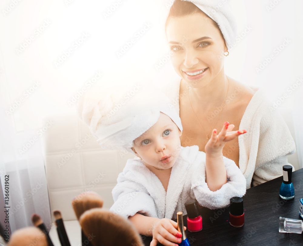Beautiful woman and her daughter making manicure Beautiful woman and her daughter making manicure