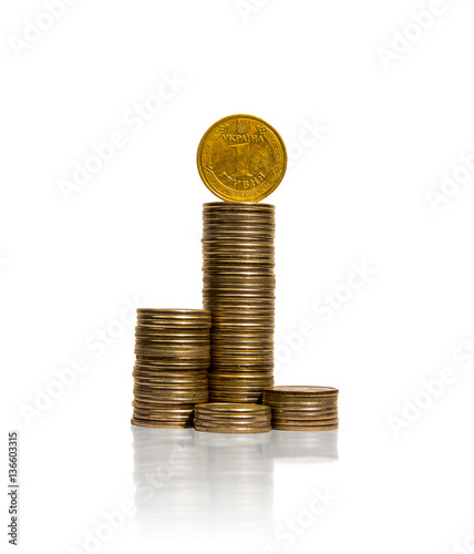 Several piles of coins with ukrainian coin on top