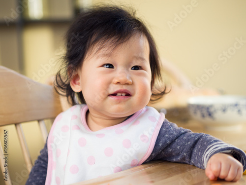 Baby girl sitting on high chair waiting for food