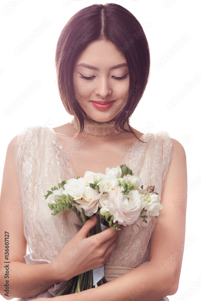 Beautiful asian woman in white dress with bouquet of flowers in hands