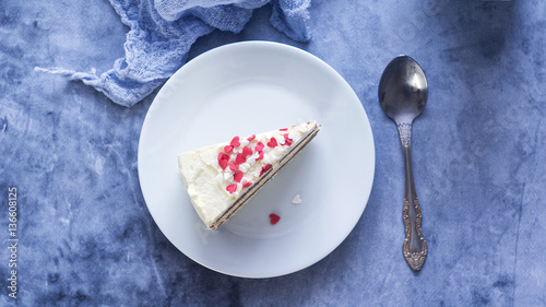 Close up shot of a piece of a lemon layer cream cake with Valentines Day heart shaped decoration