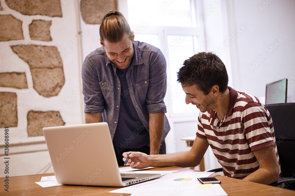 Two handsome young businessmen laughing happily Two handsome young businessmen laughing happily