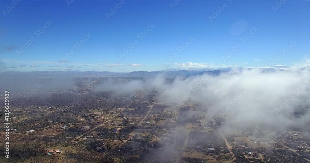 Desert City Under Clouds / Flying above a city in the desert with fast moving clouds.