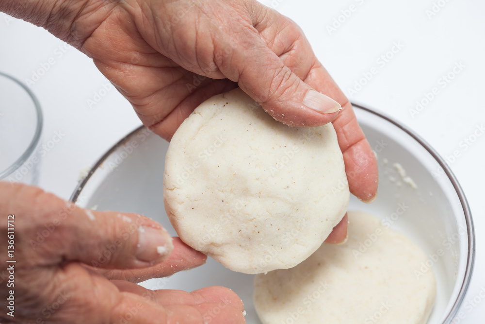 Colombian arepa dough preparation flatten the dough balls a bit with
