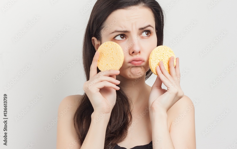 sad woman holds near the face two sponge sad woman holds near the face two sponge