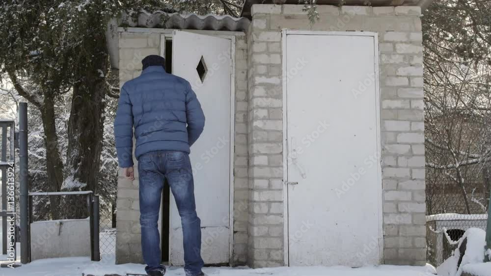 Man go to a brick toilet in the village in the winter Man go to a brick toilet in the village in the winter